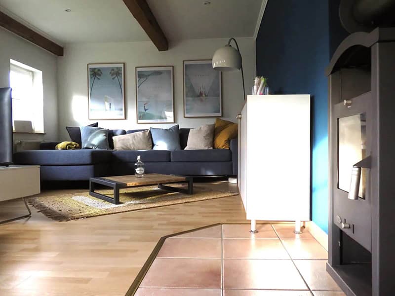 Mukkeliges Wohnzimmer mit großem Sofa und Kamin